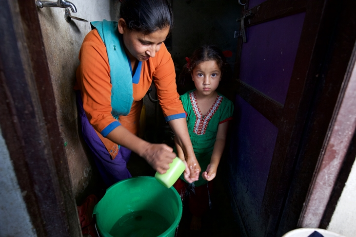 Parvati Puri helping her daughter Jenisha to wash hands before eating. Photo Credit: Mithila Jariwala