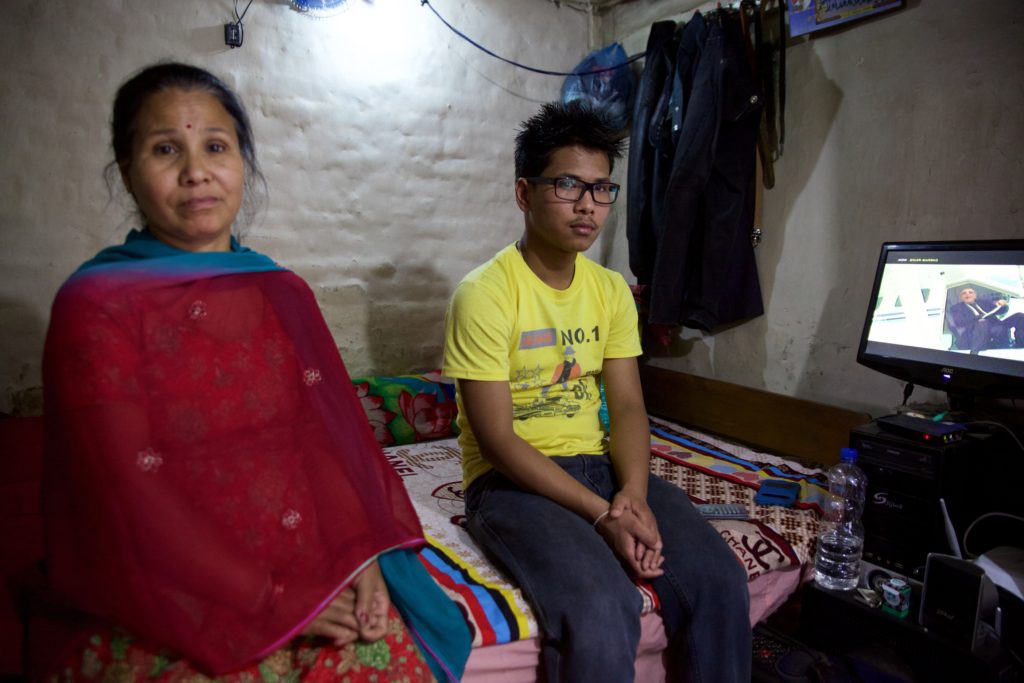 Suzen sitting with his mother, Prem, in their home three days after being discharged from Dhulikhel Hospital. He has had no fever following the discharge, but is still feeling weak and has low blood pressure. Photo Credit: Mithila Jariwala