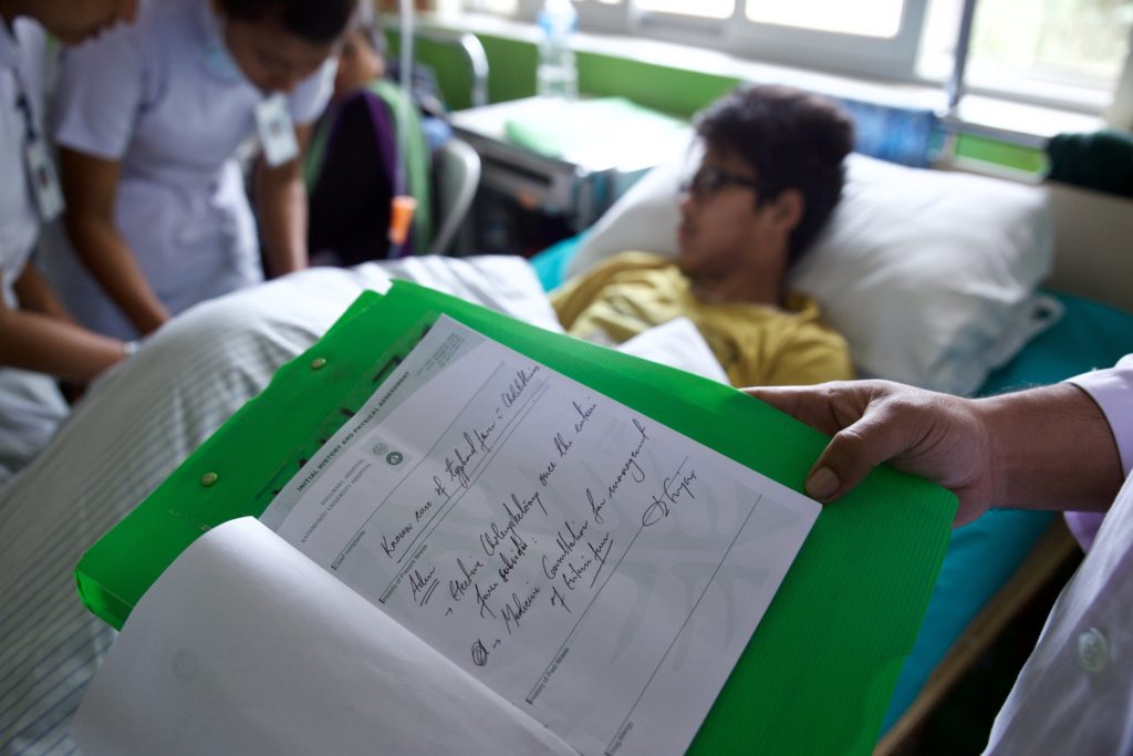 Suzen’s medical team at Dhulikhel Hospital review his diagnosis of typhoid after he was transferred from Bhaktapur Hospital to receive better care. Photo Credit: Mithila Jariwala