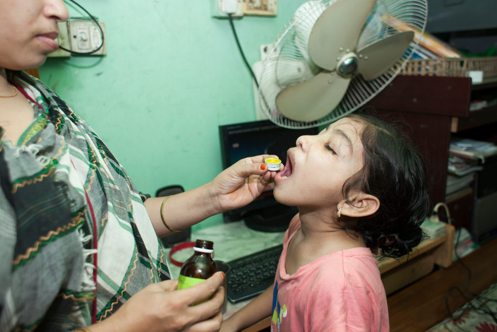 Nishita’s mother, Rehana, gives her vitamins to help her stay healthy. Photo credit: Suvra Kanti Das