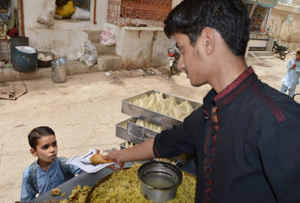 Asim buys samosas, one of his favorite foods, from a street vendor near his house.