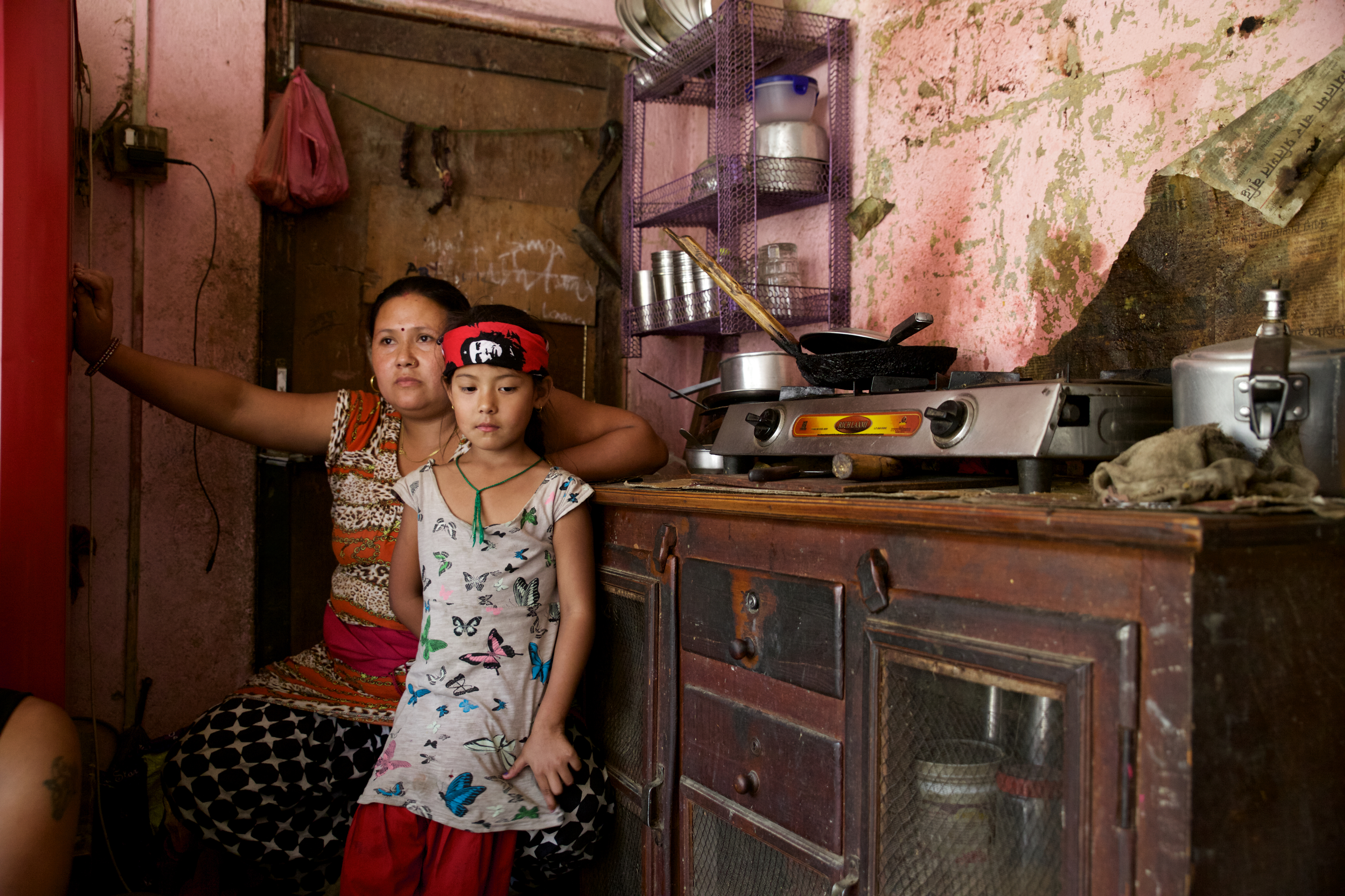Ayusha sits in the kitchen with her mother, Janu. Like many suspected typhoid cases, Ayusha was never brought to the hospital and did not receive medical care.
