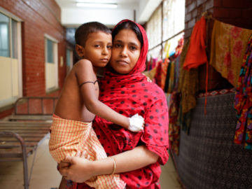 Samir, six, is cradled in the arms of his mother, Hasina Akhter. A housewife, she is now searching for a way to earn money to pay Samir’s medical bills.