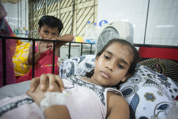 Nurunnahar had to miss school for two weeks with a case of typhoid that sent her to the hospital. One of her younger siblings is seen here watching over her hospital bed.