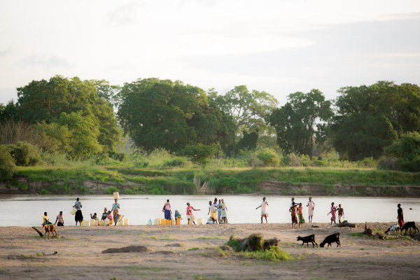 Villagers in Kenya gather at the bank of a river to gather water. When drought causes water sources to run dry, many resort to unsafe water sources.