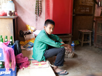 Eleven-year-old Ayush Lama sits in his home. He was the first in his family to get sick with typhoid.