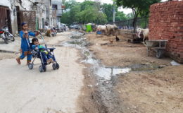 Children play in a street with an open drain in Pakistan. Photo: Raja Khalid Shabbir.