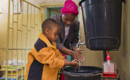 Young boy washes hands at health center in Kafue District, Zambia. PATH/Gareth Bentley