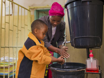 Young boy washes hands at health center in Kafue District, Zambia. PATH/Gareth Bentley