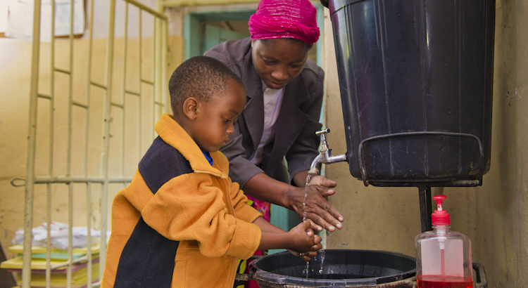 Young boy washes hands at health center in Kafue District, Zambia. PATH/Gareth Bentley