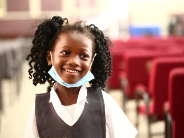 happy child smiles after receiving her typhoid vaccine