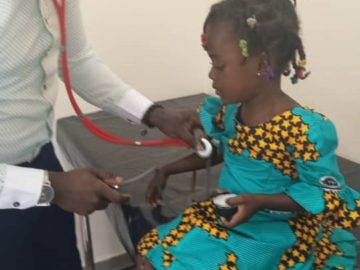 Doctor checks girl's heartrate before administering TCV in Ghana