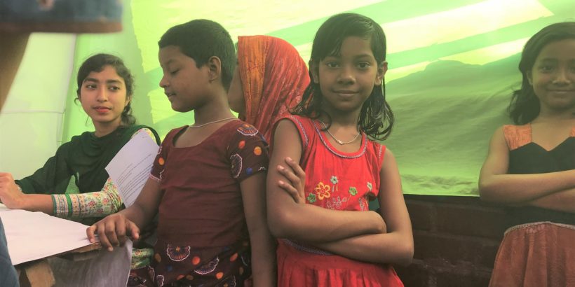 Girl in Bangladesh crosses her arms and looks at the camera