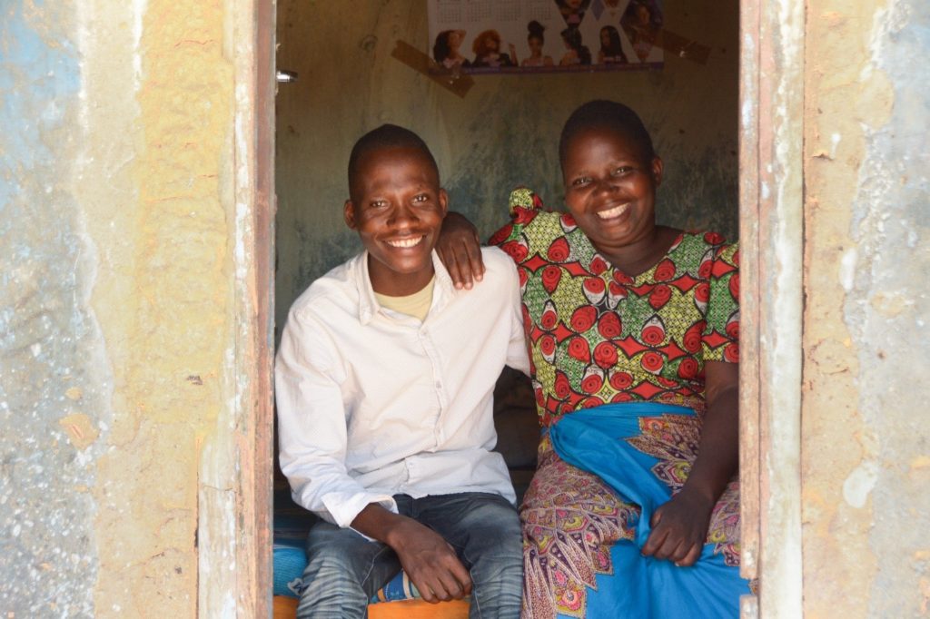 Alubi sitting with his sister as he recovers from typhoid.