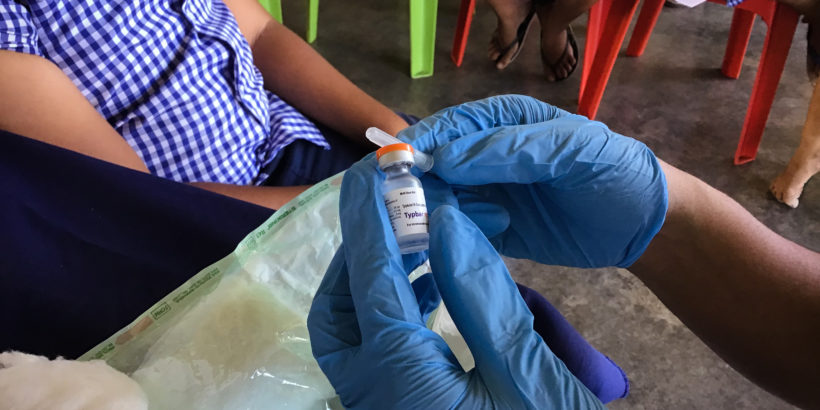 Health care worker's gloved hands hold TCV vial. Credit: Susan Nimarota Brown