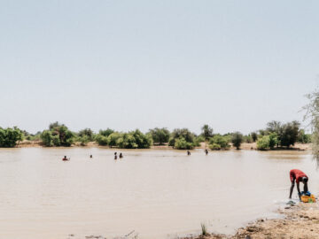 Young men swimming in a lake created during the rainy season in Matam, Senegal. PATH/Gabe Bienczycki