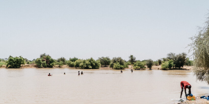 Young men swimming in a lake created during the rainy season in Matam, Senegal. PATH/Gabe Bienczycki
