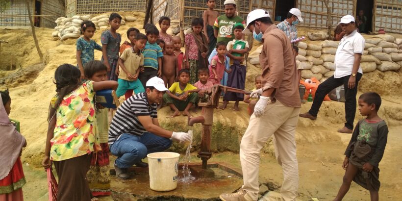 icddr,b team tests water supplies in Rohingya refugee camp, surrounded by crowd