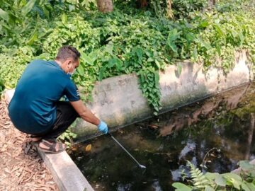 A man gathers a water sample to look for bacteriophages to help determine typhoid burden