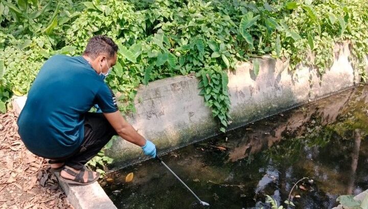 A man gathers a water sample to look for bacteriophages to help determine typhoid burden