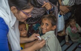 A smiling boy receives the typhoid conjugate vaccine during a 2018 vaccination campaign in Karachi, Pakistan.