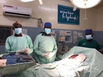Three surgeons at the hospital in Galmi, Niger, stand in the operating room ready to treat patients with typhoid intestinal perforation.