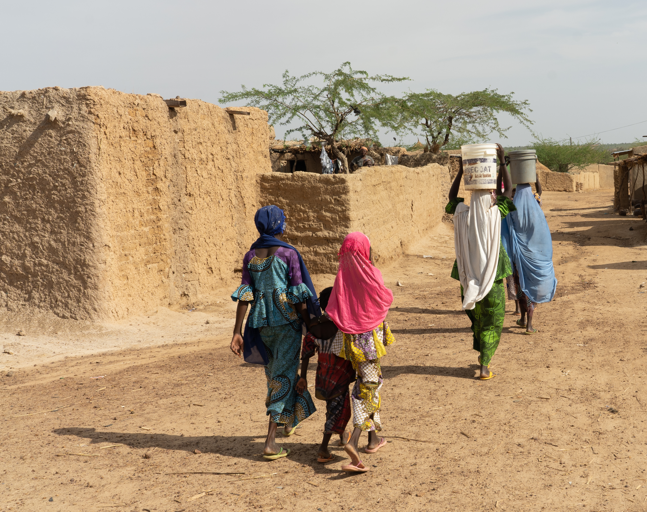 Three girls walk with their mothers in rural Galmi, Niger. All of them received emergency treatment for typhoid intestinal perforation.