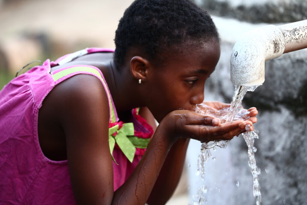 A child drinks water from a handpump in Liberia. PATH/Nurudeen Sanni