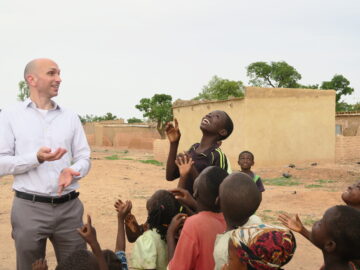 TyVAC Director Dr. Matthew Laurens pictured with a group of children.