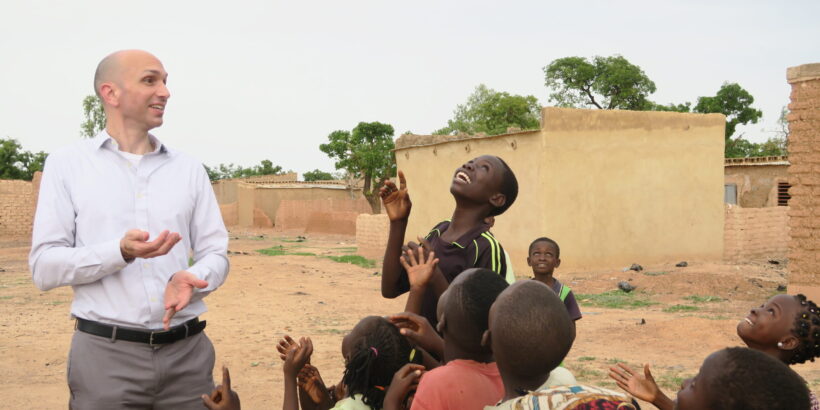 TyVAC Director Dr. Matthew Laurens pictured with a group of children.