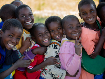 CHildren smile as they queue up for the integrated vaccination campaign in Phalombe, Malawi.