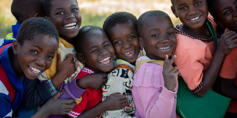 CHildren smile as they queue up for the integrated vaccination campaign in Phalombe, Malawi.