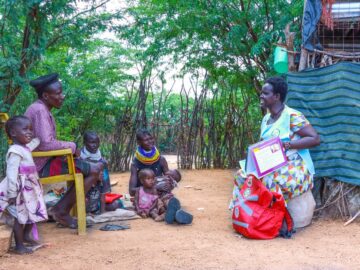 Lupeyo, a father from Kakuma, Turkana, Kenya, sits with a community health promoter. Lupeyo is one of many fathers in Kenya who recognize that vaccines work.