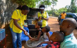 A vaccinator gives a TCV vaccination card to a child in Busia County, Kenya, during the country’s TCV introduction campaign in July 2025.