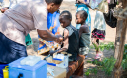 A vaccinator delivers typhoid conjugate vaccine (TCV) to a child in Malawi during the country's TCV introduction campaign.