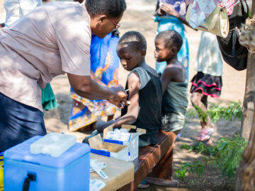 A vaccinator delivers typhoid conjugate vaccine (TCV) to a child in Malawi during the country's TCV introduction campaign.