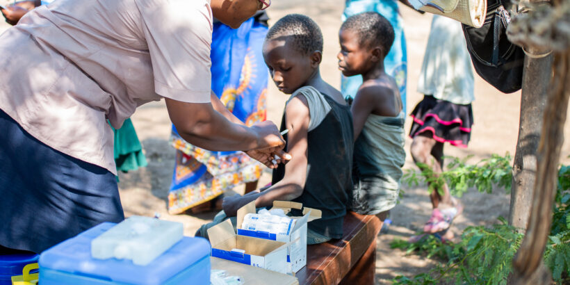 A vaccinator delivers typhoid conjugate vaccine (TCV) to a child in Malawi during the country's TCV introduction campaign.